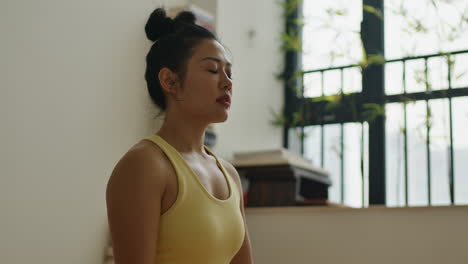 breathwork meditation, close up of young asiatic woman sitting in her home and focusing her mind while meditating alone