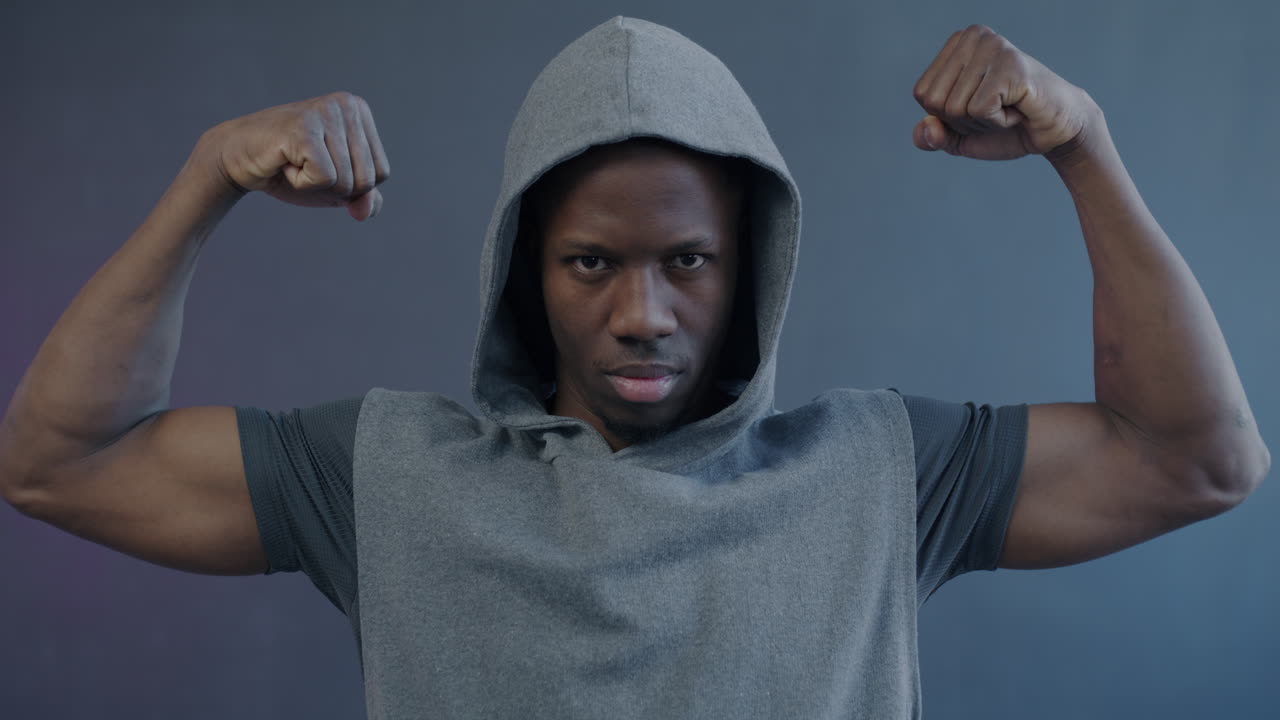 Man flexing muscles in a hoodie