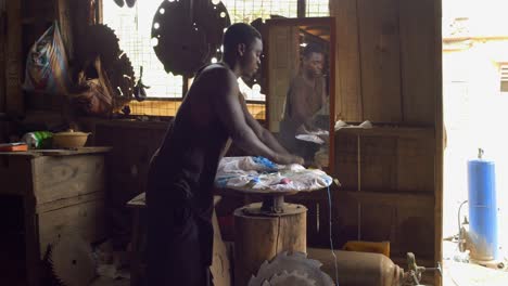 african american man works packing a metal saw in his workshop in africa