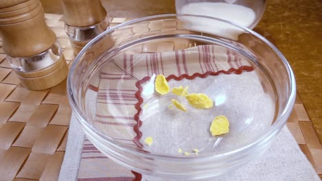 Crispy-yellow-corn-flakes-into-the-bowl-for-the-morning-a-delicious-Breakfast-with-milk.-Slow-motion-with-rotation-tracking-shot.