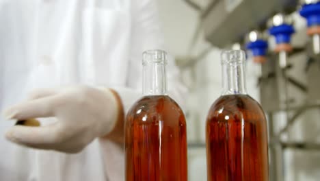 male worker putting lid on liquor bottles 4k