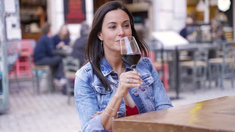 mujer disfrutando de un vaso de vino rojo al aire libre