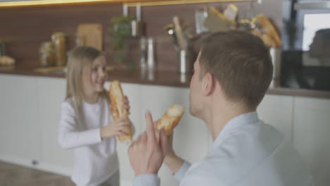 divertido padre e hija cantan, bailan y juegan con comida en casa