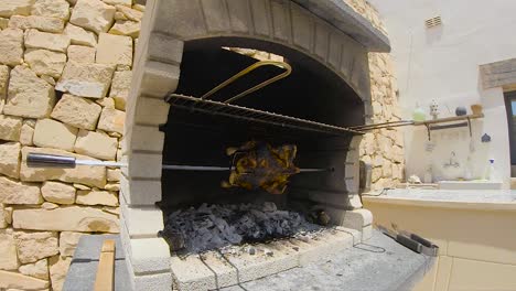 pollo asado girando en una barbacoa de ladrillos de madera y carbón asado a cámara lenta