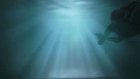 a girl floats to the surface under water against a background of sunshine