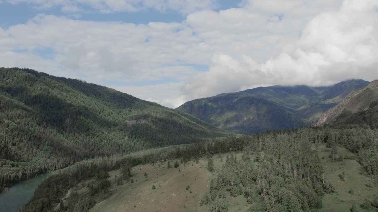 Filmato drone della valle di Ak-Kem con un fiume serpeggiante, foresta di taiga e verdi pendii montuosi sotto un cielo nuvoloso, Repubblica dell'Altai, Russia