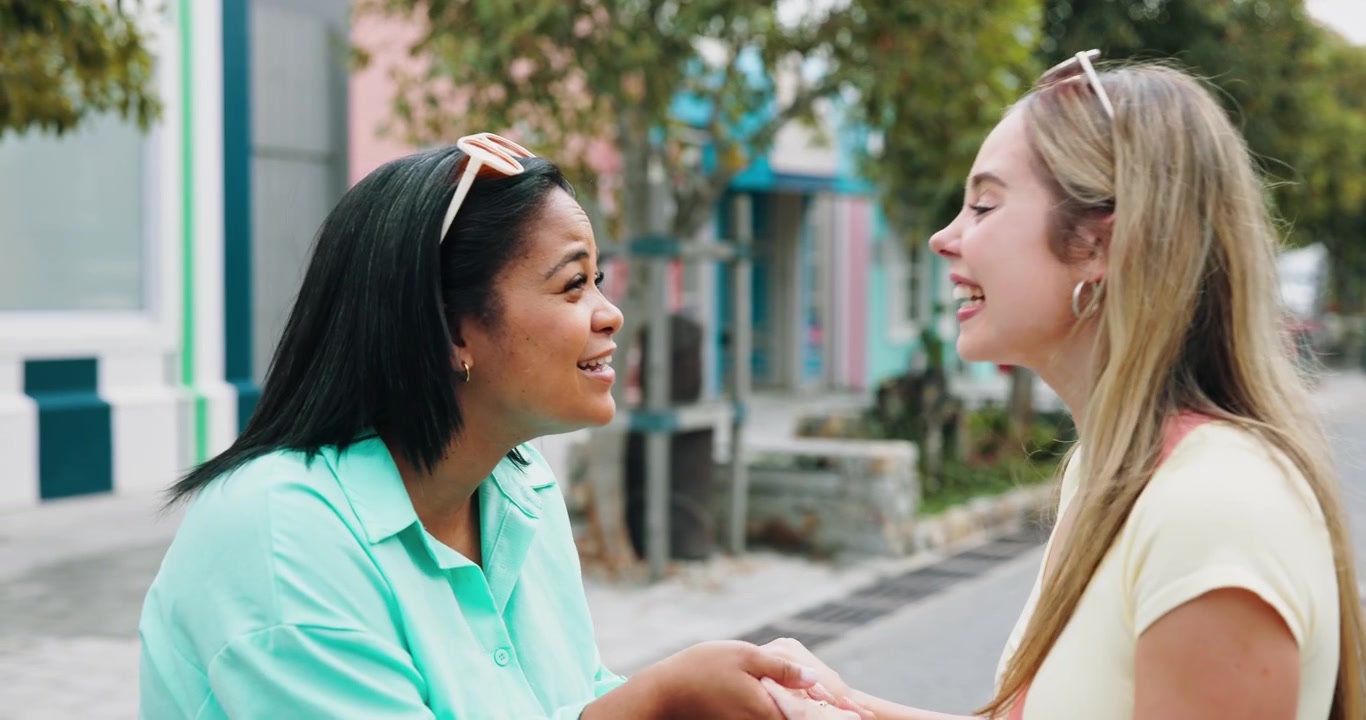 Due giovani donne che si salutano con un abbraccio e una conversazione