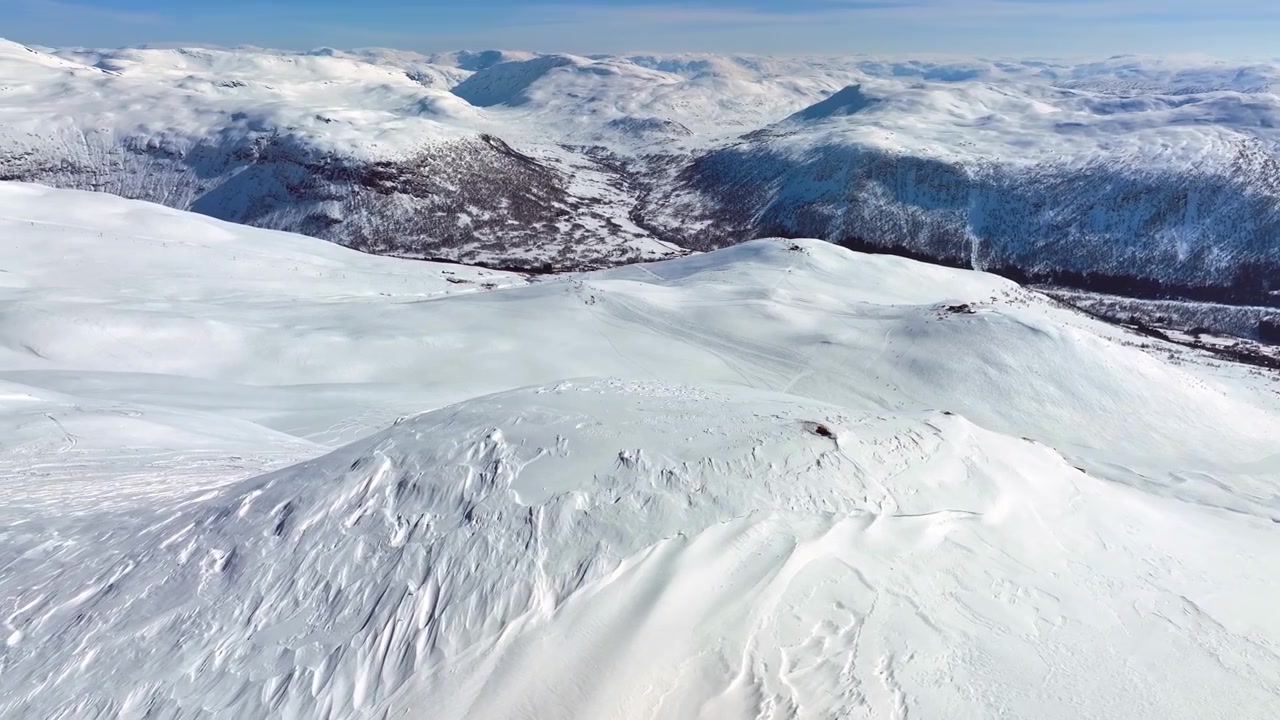 Myrkdalen skiing slopes seen from a distance with a snowy mountain hill in foreground and Myrkdalen valley in background