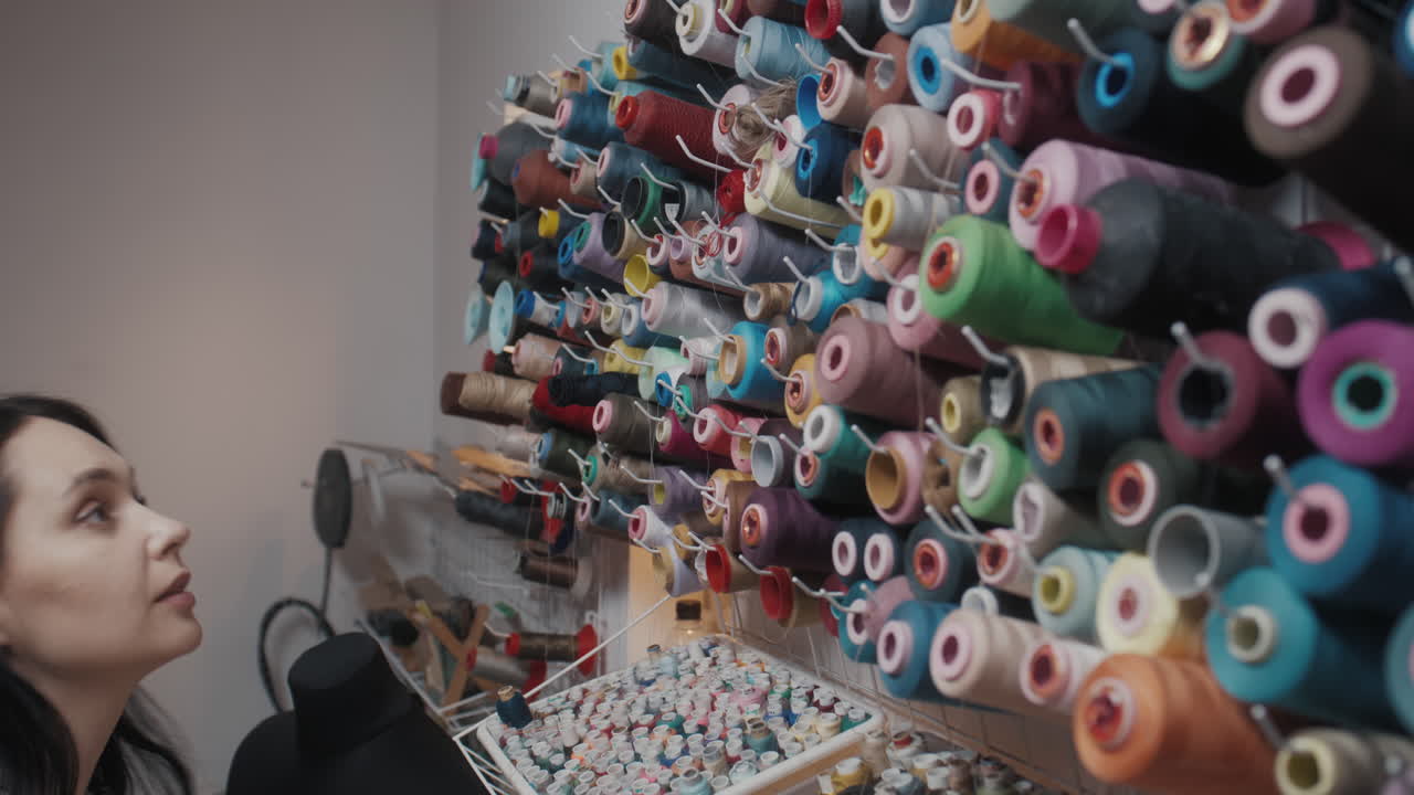 Seamstress selecting thread in a sewing studio