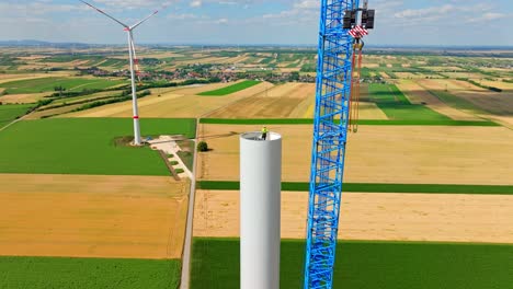 technician on top of wind turbine tower during construction in austria