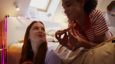 teenage girls eating pizza