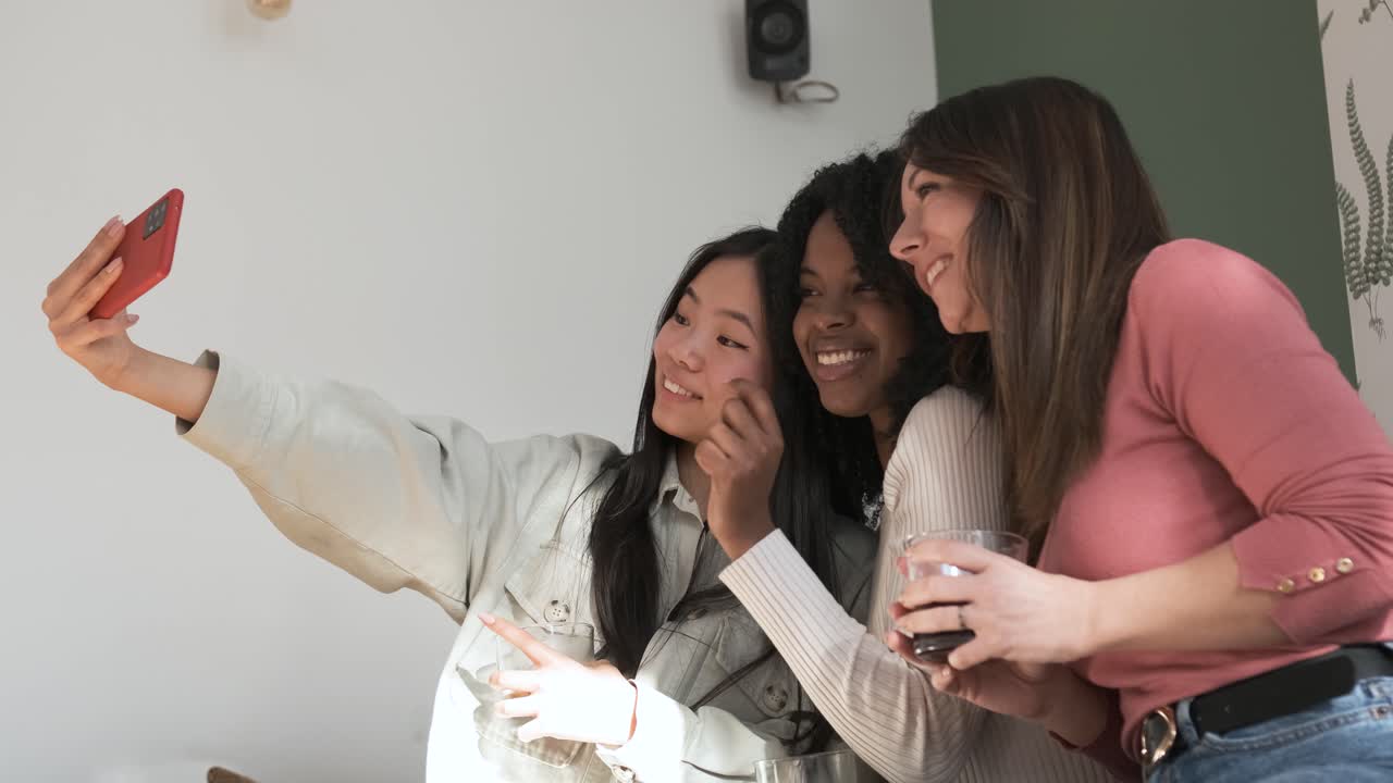 Smiling diverse friends taking selfie at home during weekend party