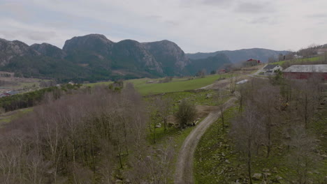 Sobrevuelo-De-Drones-Aéreos-De-La-Granja-Montañosa,-Siguiendo-Un-Camino-De-Grava