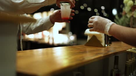 barman sirviendo cóctel sin alcohol a un invitado masculino en la recepción de la boda