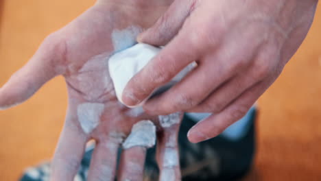 athlete smearing hands with chalk before starting game. human hands in chalk