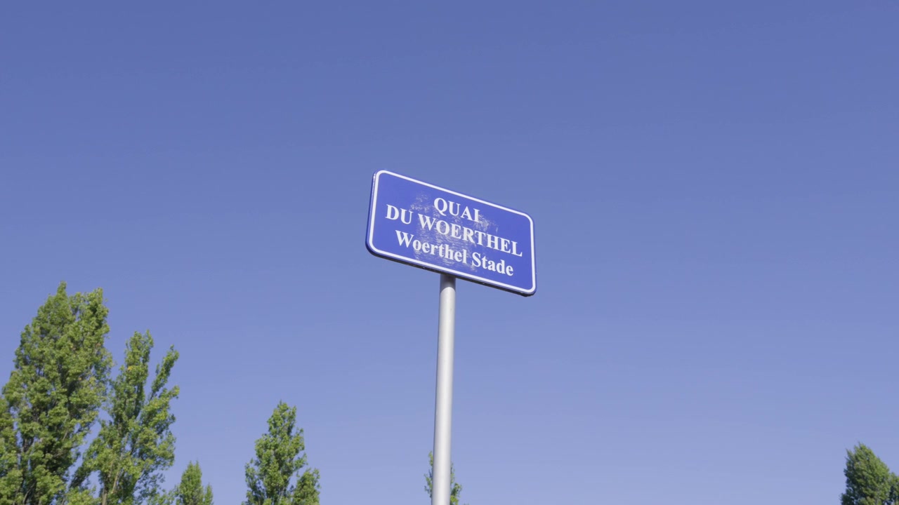 Segnale stradale blu bilingue per Quai du Woerthel Woerthel Stade a Strasburgo, Francia