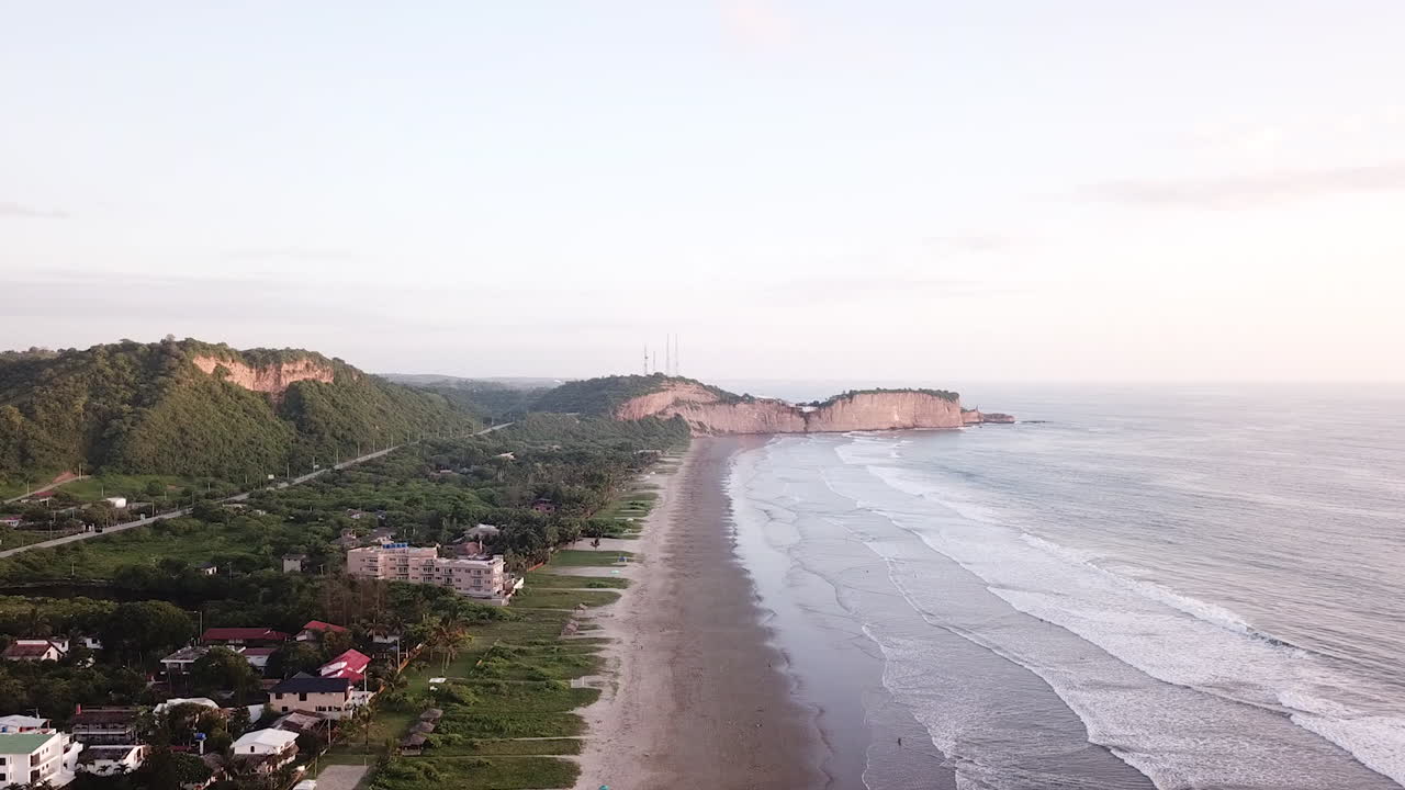 el hermoso y costoso resort isleño en la playa de olón, ecuador, compuesto por un mar tranquilo y diferentes edificios - toma aérea