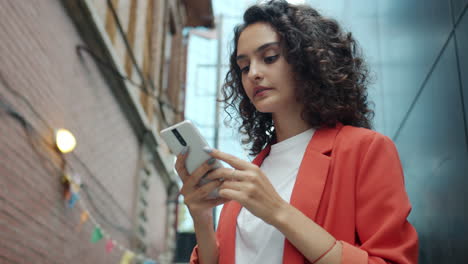 woman using smartphone in a city alley