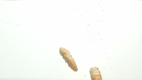 Turmeric-dropped-into-water-with-rising-air-bubbles,-close-up-view