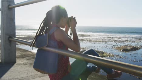 animación de un círculo sobre una mujer tomando fotos en el paseo marítimo por el mar