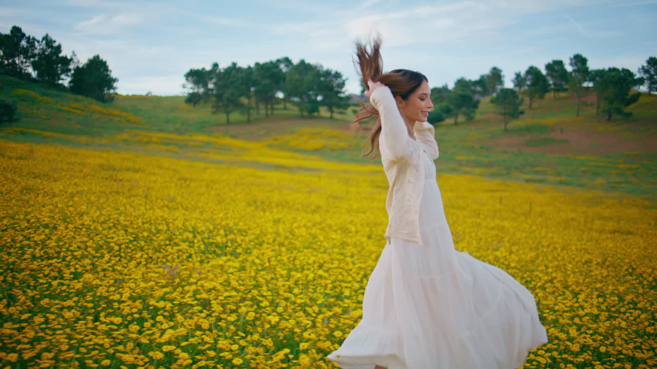 Pretty woman relaxing flowers field cloudy summer day. Carefree girl strolling