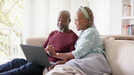 Feliz-Pareja-De-Ancianos-Afroamericanos-Usando-Una-Computadora-Portátil-En-Casa,-Cámara-Lenta