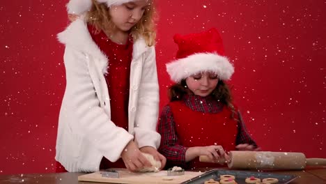 composición de video con nieve cayendo sobre el escritorio con niños preparando galletas