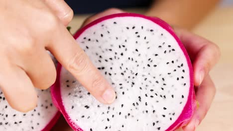 hands examining dragon fruit interior closely