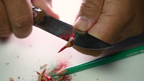 Footage-of-hands-slowly-sharpening-a-pencil-and-some-coloured-pencils-with-a-sharp-knife