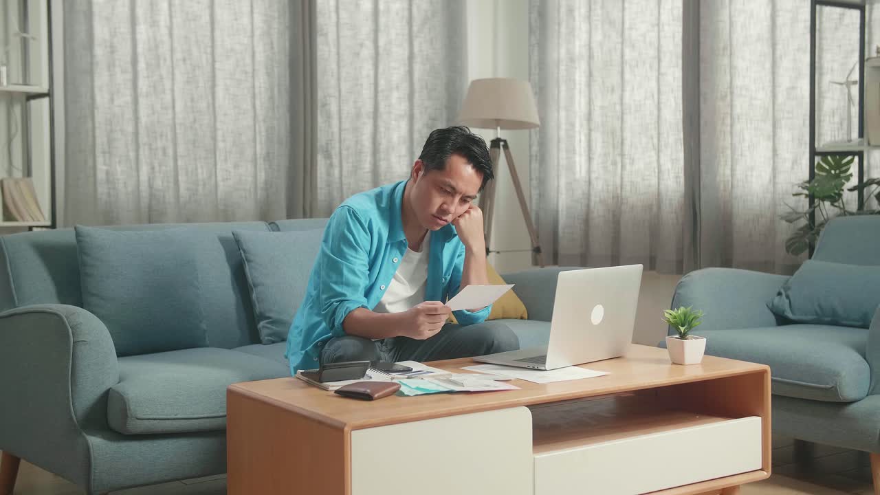 Pria Asia Dengan Laptop Melihat Tagihan Dan Sakit Kepala Karena Masalah Keuangan