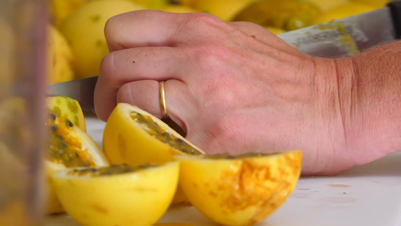 cocinero casero cortando frutas de la pasión en una tabla de cortar