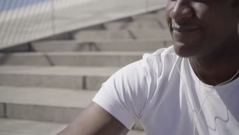 young man wearing sportswear listening music outdoor.