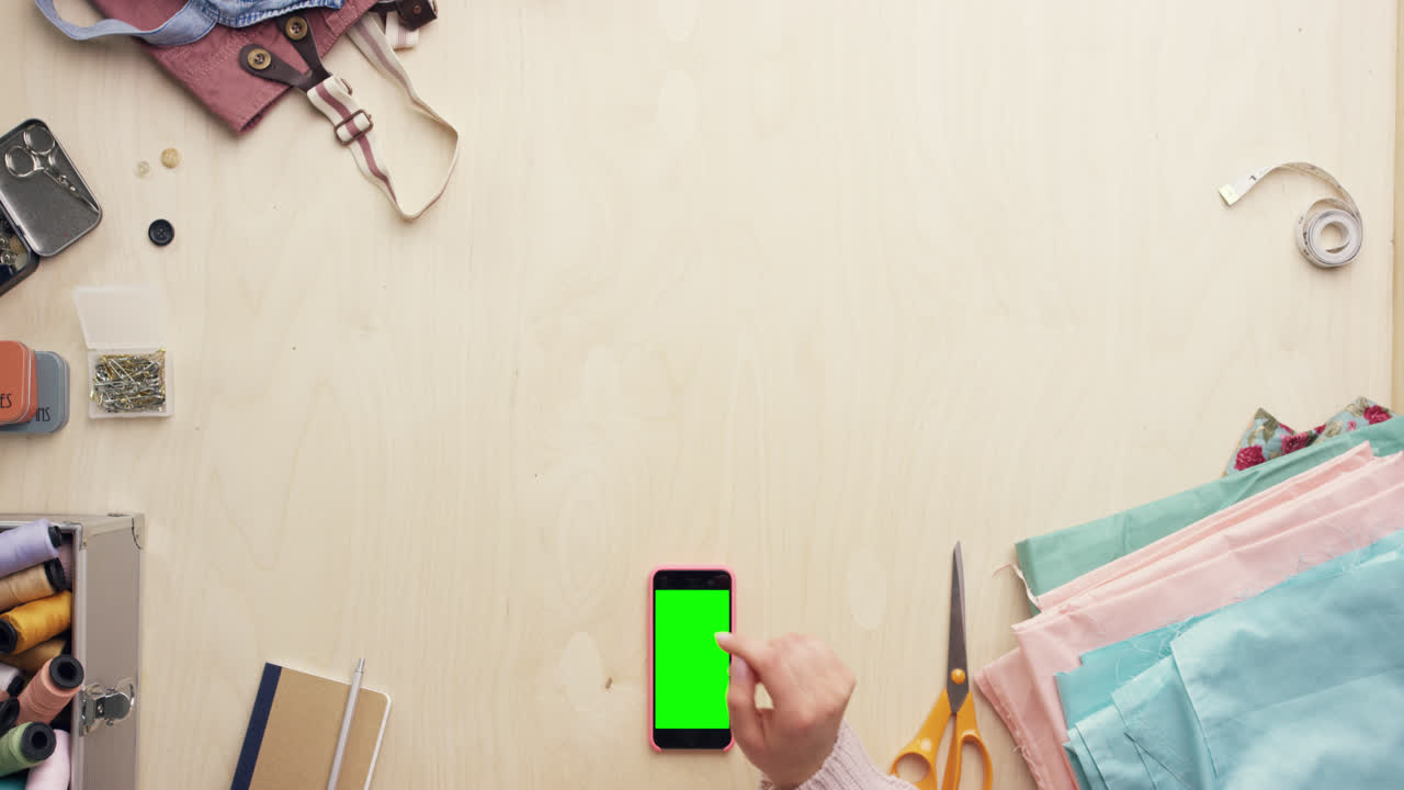 vista superior de las manos del diseñador de moda usando una aplicación de diseño de teléfono móvil trabajando en el escritorio desde arriba - dragón épico rojo