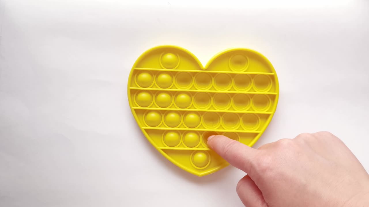New baby toy. Pop it finger play. Funny color. Adult hand squeeze round silicone. Change form. Yellow heart shape