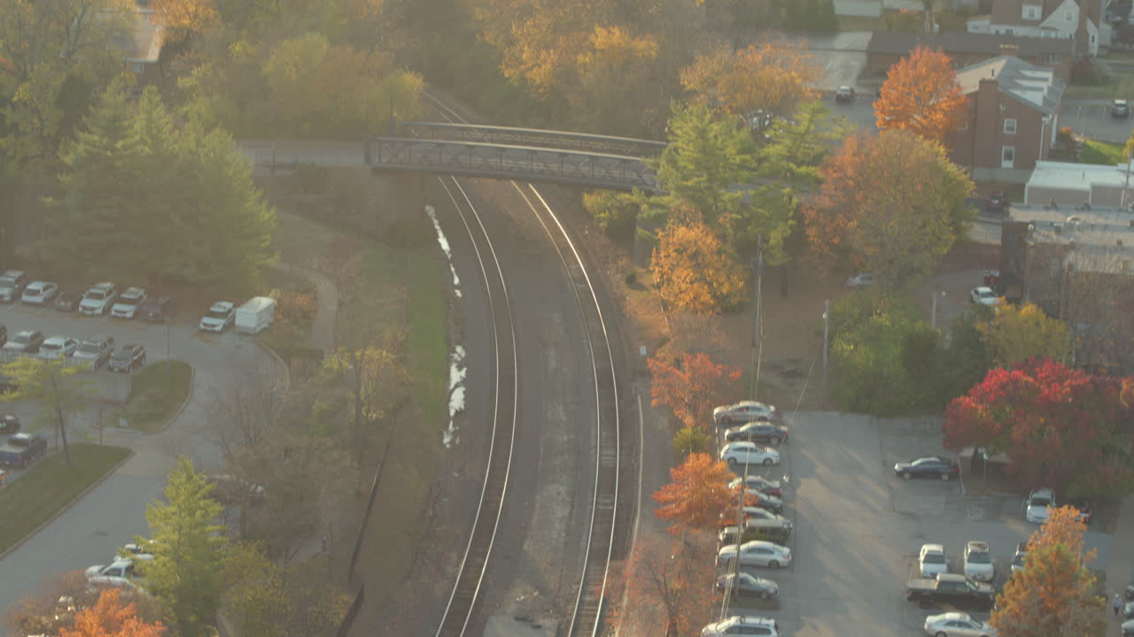 기찻길 위의 다리와 세인트의 커크우드에 있는 기차역을 드러내기 위해 아래로 기울어져 최고의 색상으로 가을 동안 나무의 공중