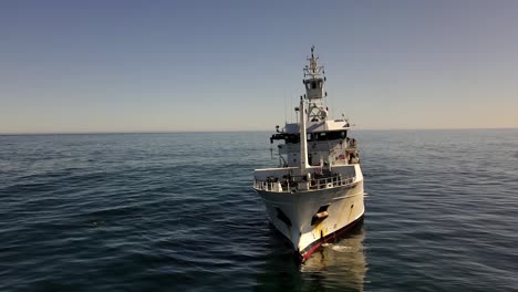 marine research vessel seen from the bow using its crane on the open ocean