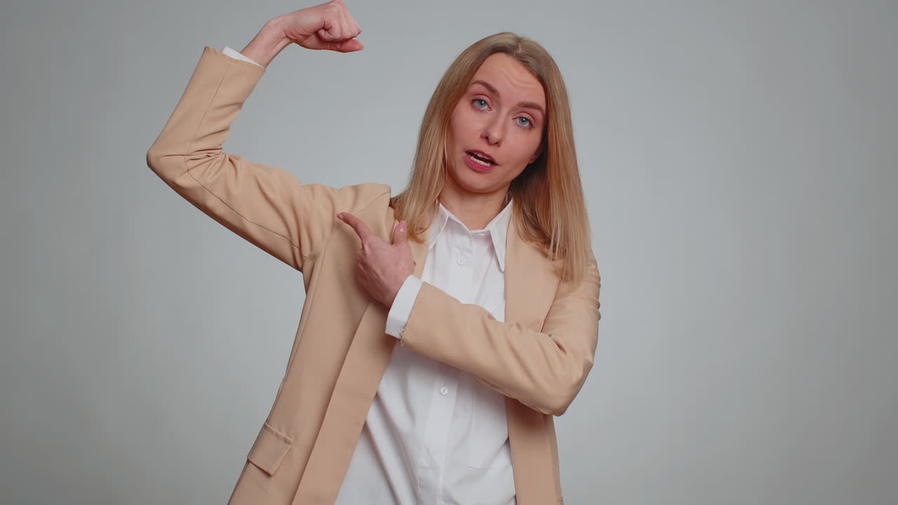 Fit sporty woman showing biceps and looking confident feeling power strength success win