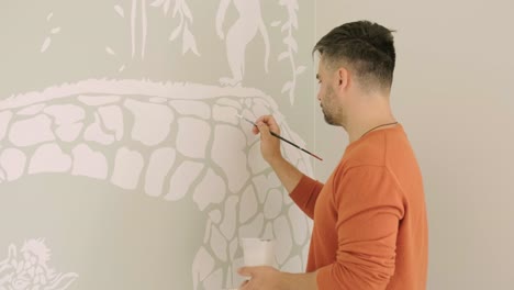 el artista está decorando las paredes con dibujos en la habitación de los niños. pintura de arte de las paredes en la casa nueva. trabajos de reparación.