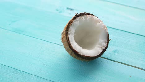 Half-coconut-on-blue-table-