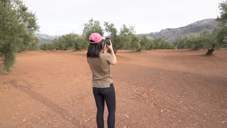 mujer grabando un video del árbol de olivo