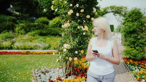 A-Young-Woman-Is-Walking-In-The-Garden-Of-Roses