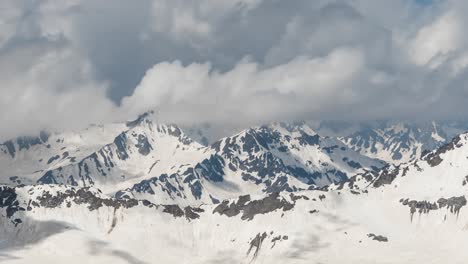 air flight through mountain clouds over beautiful snow-capped peaks of mountains and glaciers.