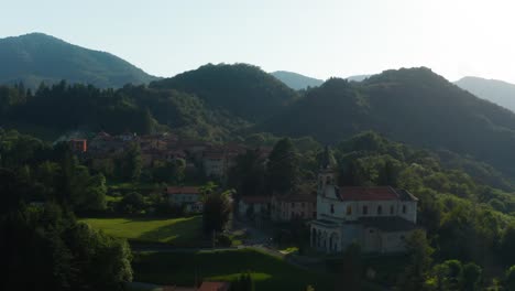 Vista-Aérea-Del-Pintoresco-Pueblo-Italiano-Ubicado-Junto-A-Colinas-Boscosas-En-Arola,-Italia