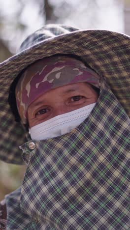 person wearing a face mask and plaid hat