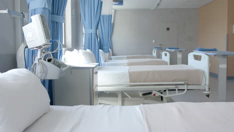 fila de camas vacías, recién hechas y equipo en una sala de hospital vacía, espacio de copia, cámara lenta