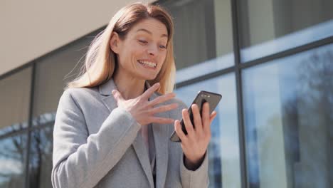 portrait amazed business woman receiving good news at street near financial district. happy woman reading good news in mobile phone app message outdoor. exited girl celebrating victory enjoy success.