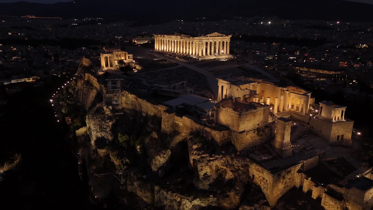 Athens, Aerial view of Beautifully illuminated Acropolis at night, circle pan right slowly from a distance,Full view of Panthenon,Erechthenion and entrance of Acropolis in shimmering lights