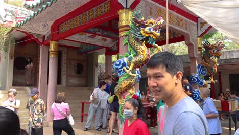 visitors exploring a temple with a dragon statue