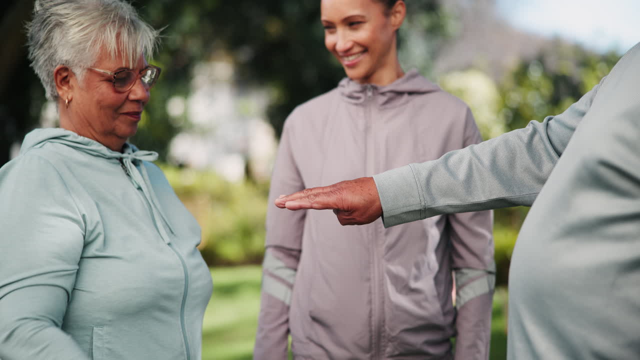 A diverse group of seniors and a younger trainer put their hands together to show teamwork and unity