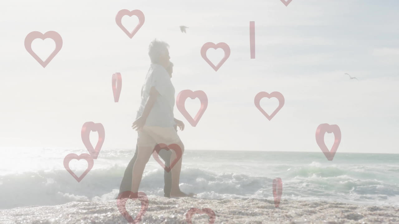Walking on beach, man with heart shapes animation overlay in background